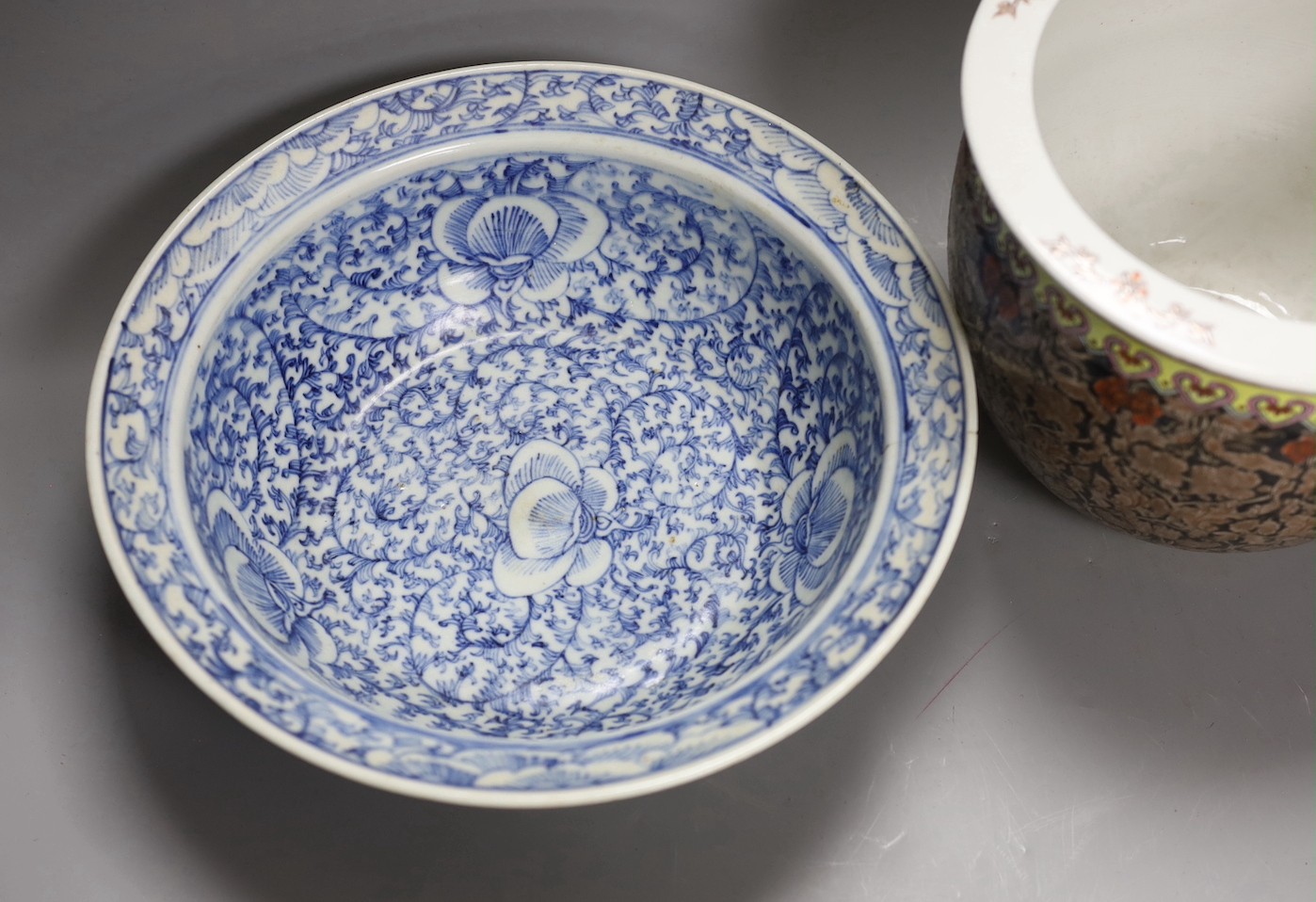 A 19th century Chinese blue and white basin and a famille rose jardiniere. Basin 29cm diameter